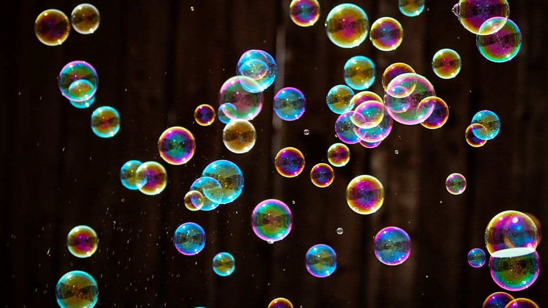 Water drops on soap bubble films act like merging galaxies